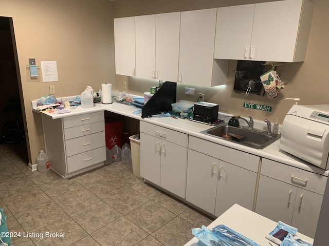 8910 Main St, Campbellsburg, KY 40011 - kitchen featuring light tile patterned floors, light countertops, a sink, and white cabinets