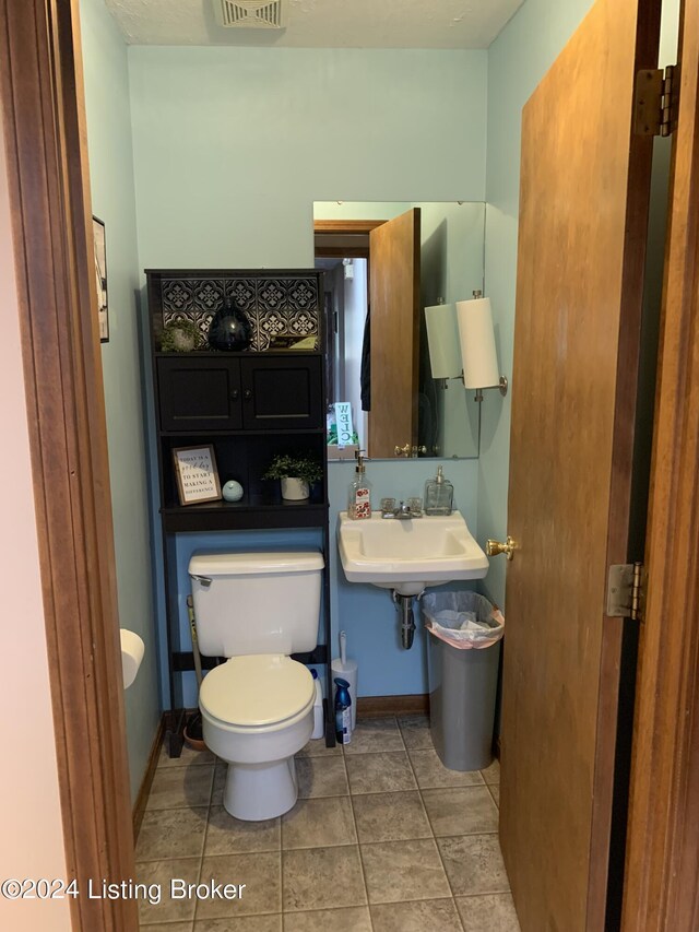 bathroom with toilet and tile patterned floors