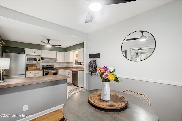 dining area with ceiling fan, light hardwood / wood-style flooring, and sink