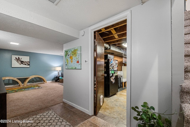 hall with a textured ceiling and carpet