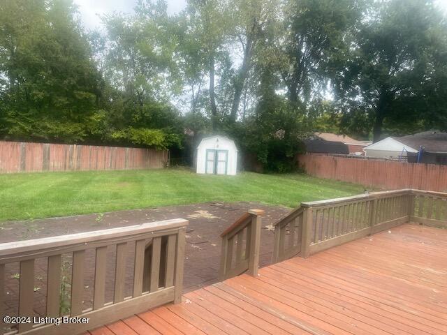 deck featuring a lawn and a storage unit