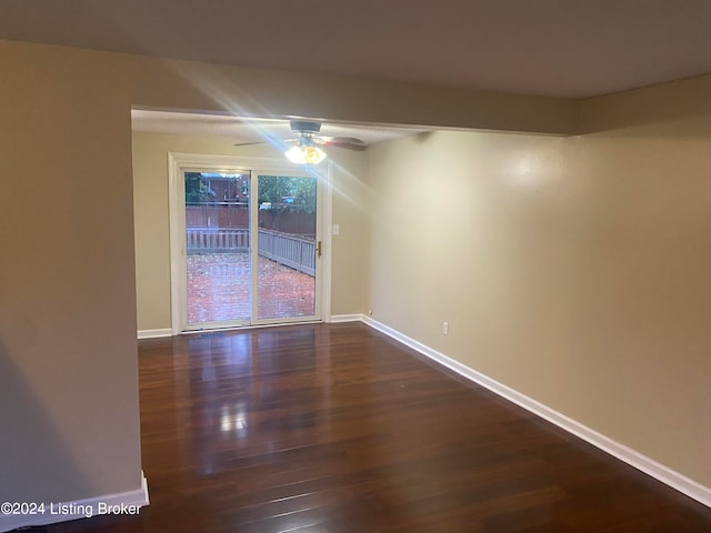 empty room with dark hardwood / wood-style floors and ceiling fan