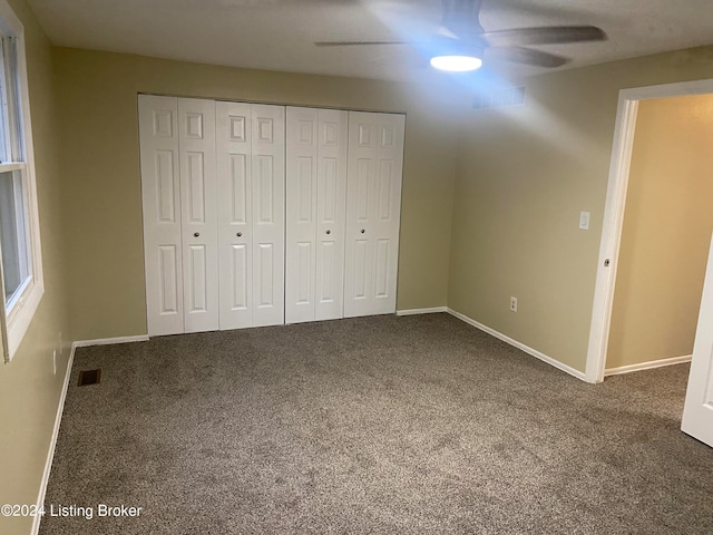 unfurnished bedroom with carpet floors, ceiling fan, and a closet