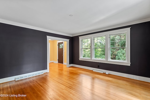 unfurnished room featuring light wood-type flooring and crown molding