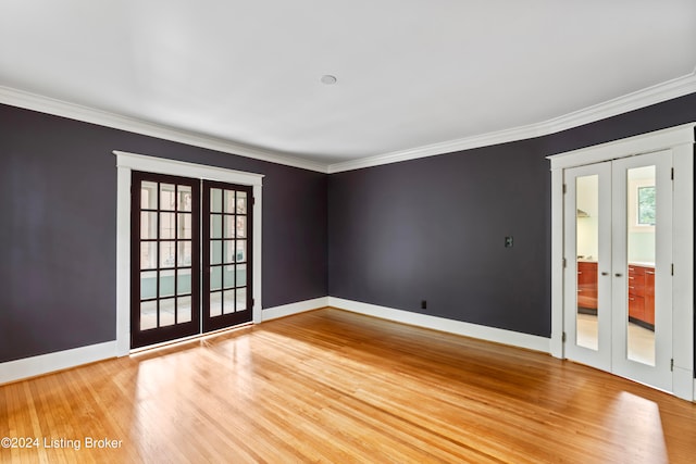 unfurnished room with french doors, crown molding, and wood-type flooring