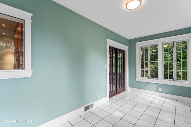 tiled empty room with french doors