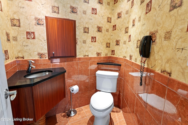 bathroom featuring vanity, tile walls, toilet, and tile patterned floors