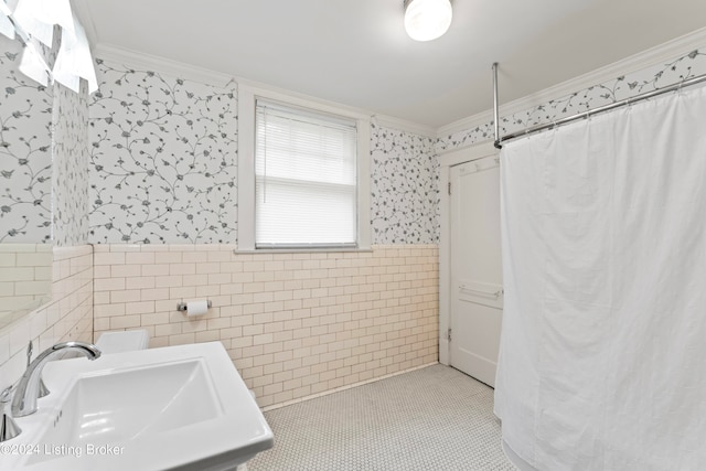 bathroom featuring tile walls, crown molding, sink, and tile patterned floors