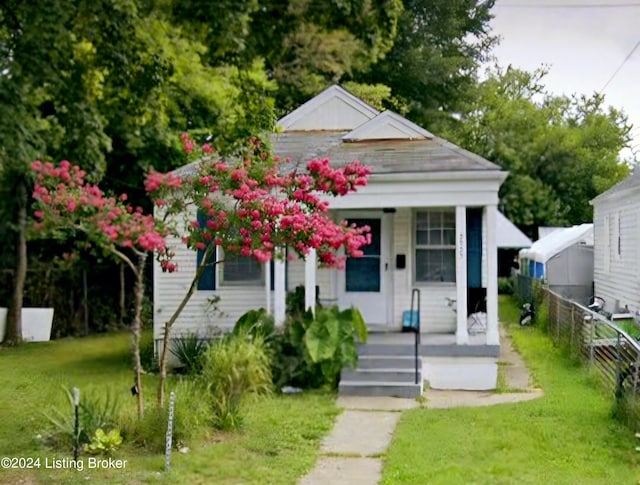 bungalow-style home with covered porch and a front yard