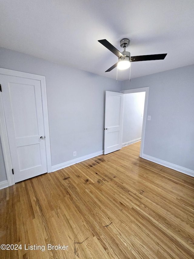 empty room with ceiling fan and light hardwood / wood-style floors