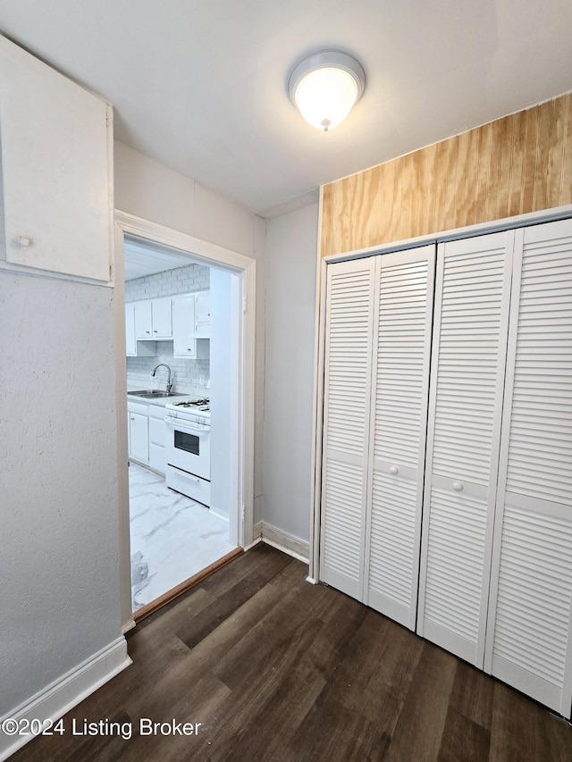 corridor with dark wood-type flooring and sink