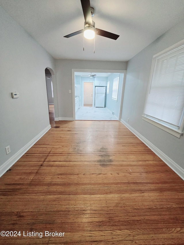 unfurnished living room featuring ceiling fan and light hardwood / wood-style floors