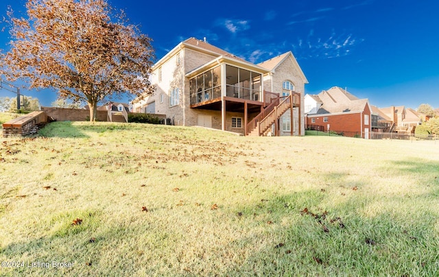 back of property featuring a sunroom and a yard