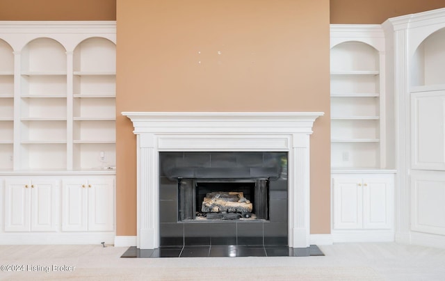 room details with carpet floors, a tile fireplace, and built in features