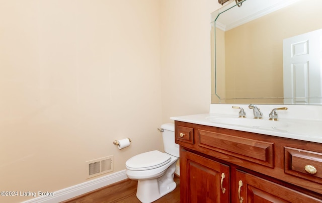 bathroom featuring ornamental molding, vanity, hardwood / wood-style floors, and toilet