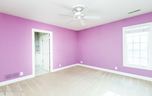 carpeted spare room with ceiling fan