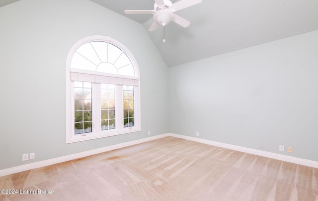 spare room with vaulted ceiling, ceiling fan, and light colored carpet