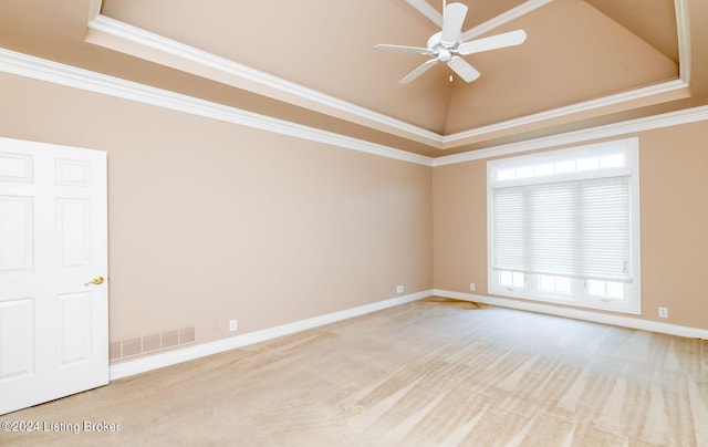 carpeted spare room featuring ceiling fan, a raised ceiling, and crown molding