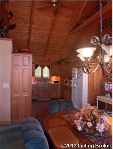 dining area with wood ceiling, vaulted ceiling with beams, and wood walls