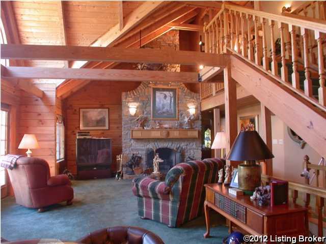 living room with wood walls, stairs, carpet flooring, beam ceiling, and a fireplace