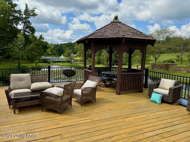wooden terrace featuring an outdoor hangout area and a gazebo