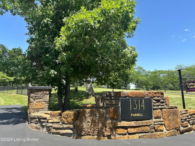 community / neighborhood sign with a yard