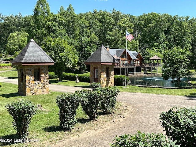 view of community with a gazebo, a yard, and a water view