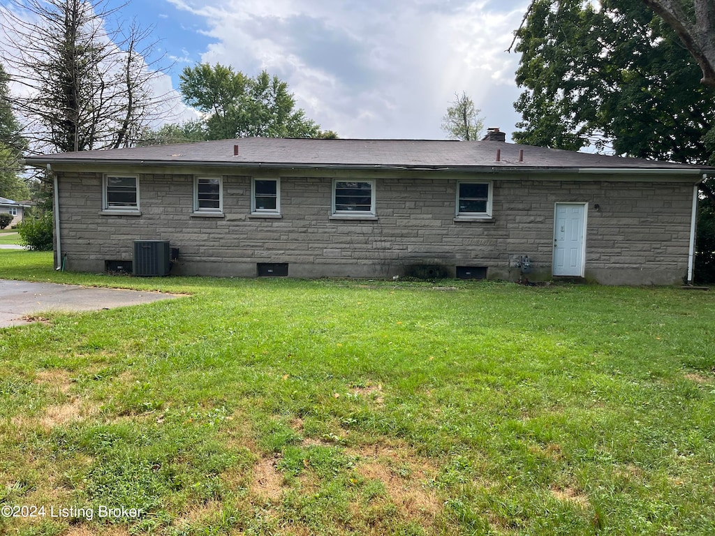 back of property with a lawn and central air condition unit