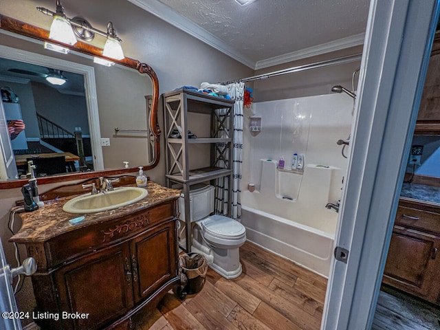 full bathroom with hardwood / wood-style floors, crown molding, shower / bath combo with shower curtain, vanity, and toilet