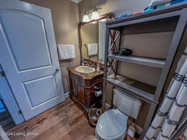 bathroom with hardwood / wood-style floors, vanity, and toilet