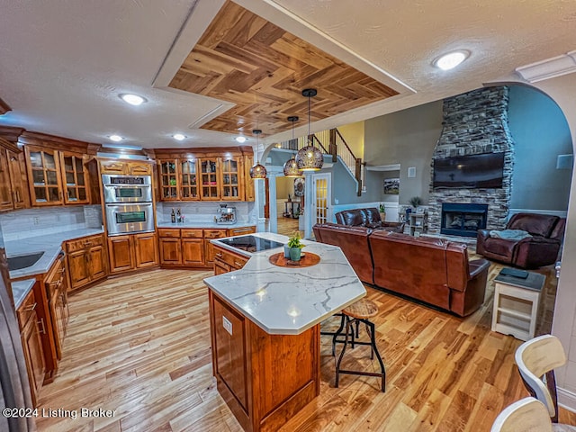 kitchen featuring light hardwood / wood-style flooring, a breakfast bar, a center island, and pendant lighting