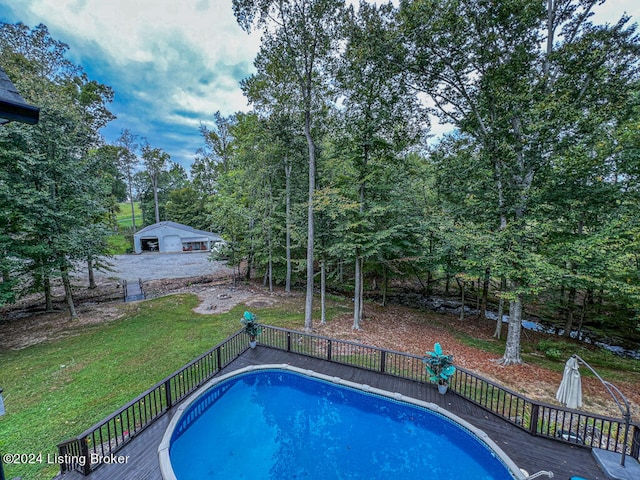 view of swimming pool with a yard and a wooden deck