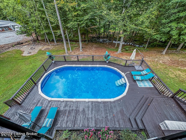 view of swimming pool with a deck and a yard