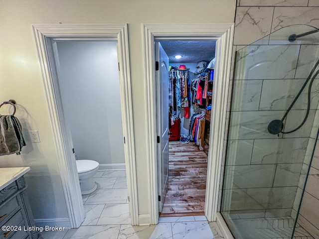 bathroom with walk in shower, vanity, toilet, and hardwood / wood-style flooring