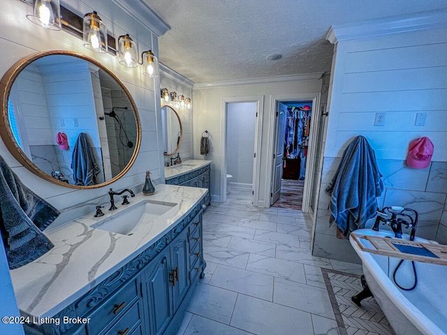 bathroom with a textured ceiling, a tub, ornamental molding, vanity, and toilet