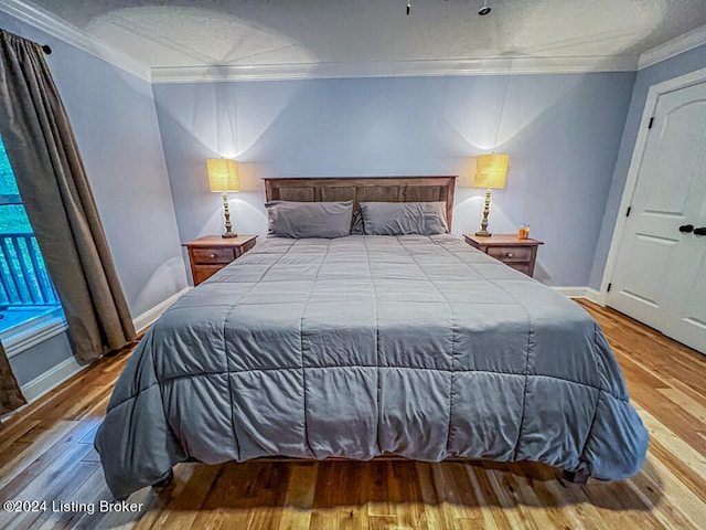 bedroom featuring wood-type flooring and crown molding