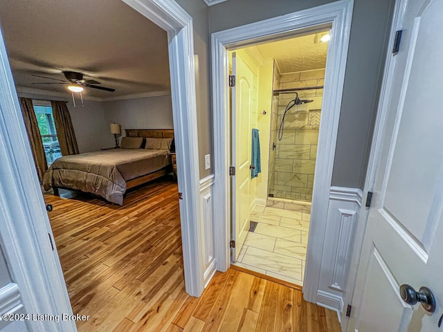 bedroom with light hardwood / wood-style flooring, connected bathroom, ceiling fan, and crown molding