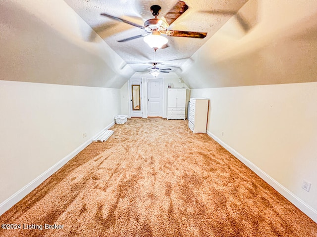 bonus room featuring ceiling fan, light colored carpet, a textured ceiling, and lofted ceiling