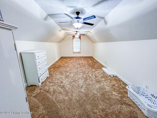 additional living space featuring a textured ceiling, lofted ceiling, ceiling fan, and light carpet