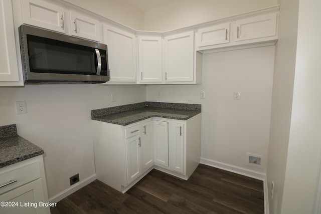 kitchen featuring dark stone counters, dark wood-type flooring, and white cabinetry