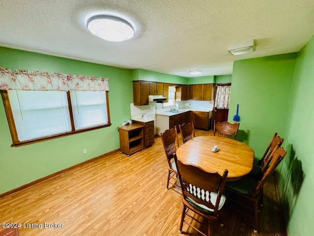 dining room with a textured ceiling, light hardwood / wood-style floors, and sink