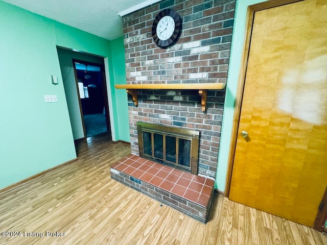 unfurnished living room featuring a textured ceiling, wood-type flooring, and a fireplace