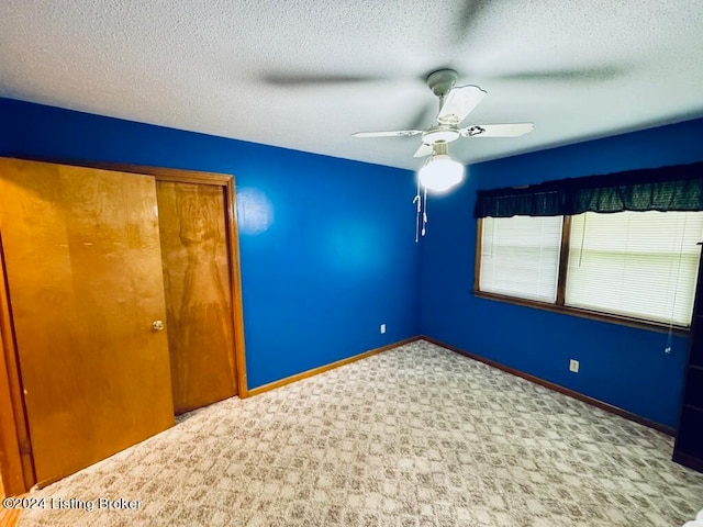 unfurnished bedroom with ceiling fan, a textured ceiling, and a closet