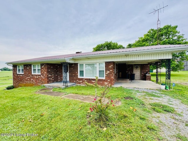 view of front of house with a front yard and a carport