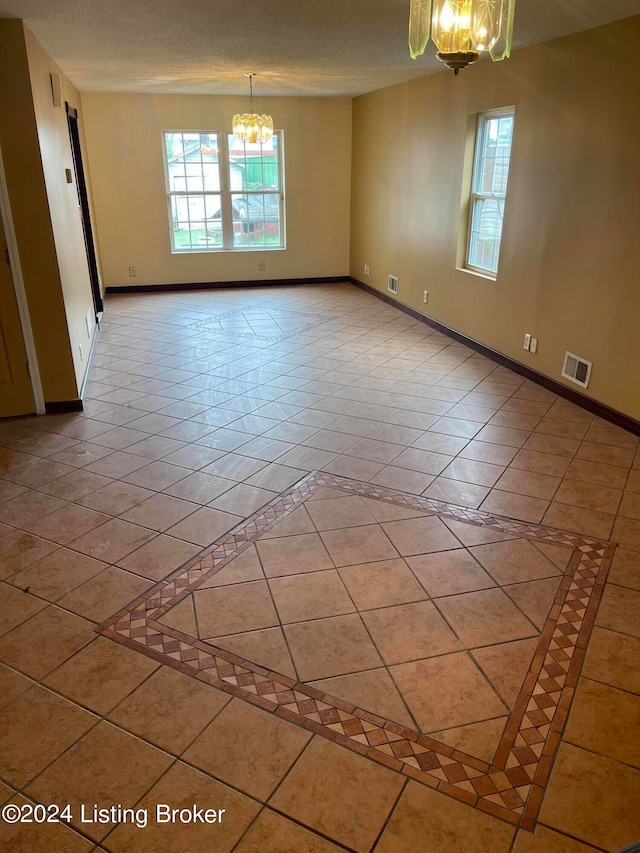 1406 Cardinal Dr, Louisville, KY 40213 - unfurnished room with an inviting chandelier, tile patterned flooring, and a textured ceiling