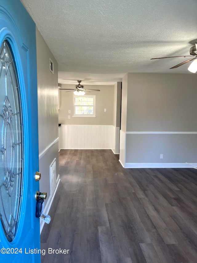 foyer featuring ceiling fan, dark hardwood / wood-style floors, and a textured ceiling