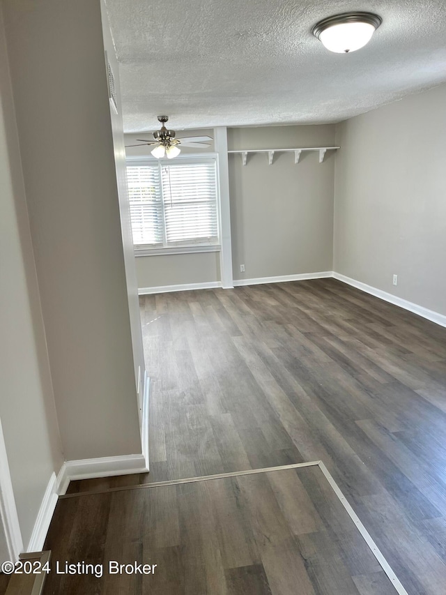 unfurnished room featuring ceiling fan, a textured ceiling, and dark wood-type flooring