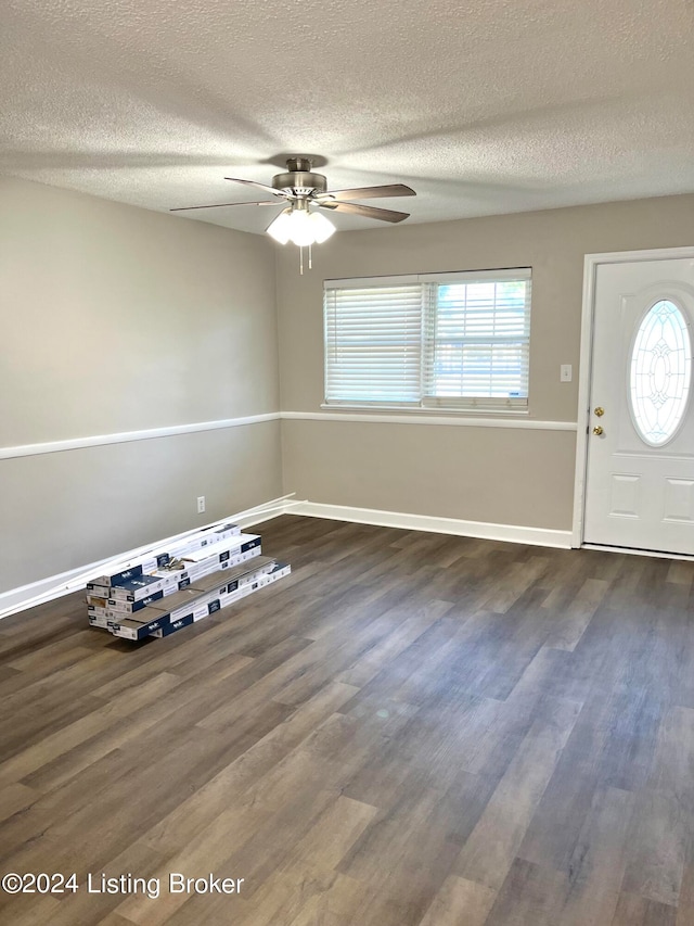 foyer featuring ceiling fan, a textured ceiling, and dark wood-type flooring