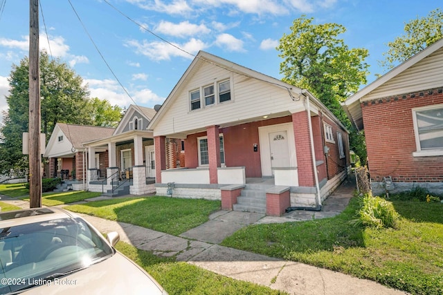 bungalow-style home featuring a porch and a front lawn