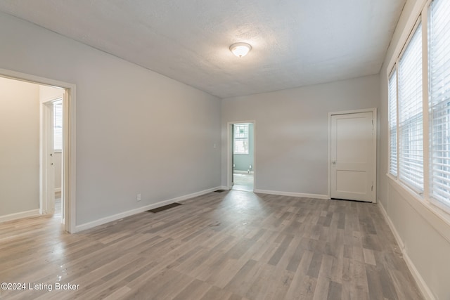 unfurnished room with wood-type flooring and a textured ceiling